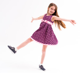 Naklejka premium Cute girl in violet short dress, happy spinning and turning around, dancing