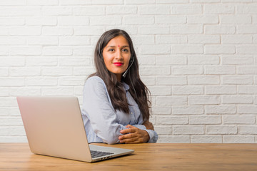 Young indian woman crossing his arms, smiling and happy, being confident and friendly. Wearing a headset.