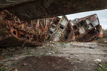 Huge rusty pieces of decommissioned marine ship that was cut and left on the shore.