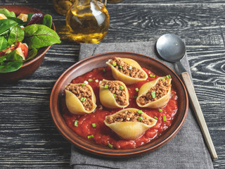 cooked pasta conchiglioni stuffed minced meat, tomato sauce plate