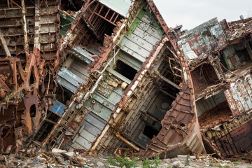 Huge rusty pieces of decommissioned marine ship that was cut and left on the shore.