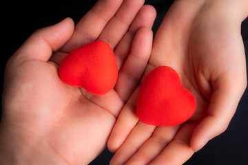 Red hearts drawing on hands of a couple holding hand in hand, lovers, symbol of love, togetherness, hands holding, love, Valentine’s Day