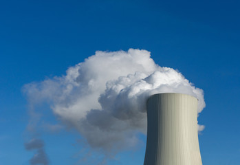 Obraz premium smoke from chimney or steam of power plant cooling tower on background of blue sky - fossil energy sources
