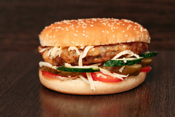 Tasty grilled prawn and beef burger with lettuce and mayonnaise served on pieces of brown paper on a rustic wooden table of counter, with copyspace