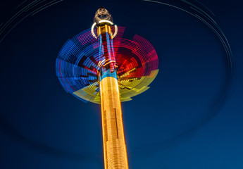 Abstract blurred multicolour spinning high speed carousel in front of dark night sky