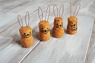 Homemade funny naughty Easter hares made from corks and metal stationery on light wooden...