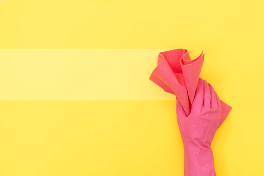 Woman holding cleaning towel against yellow background