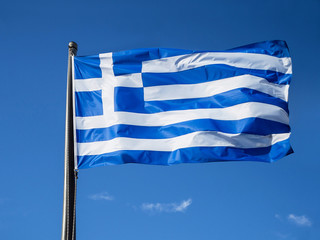 Greek flag waving in blue sky in Greece
