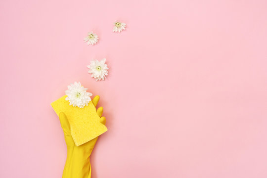 Woman holding sponge for washing with white flowers in her hands