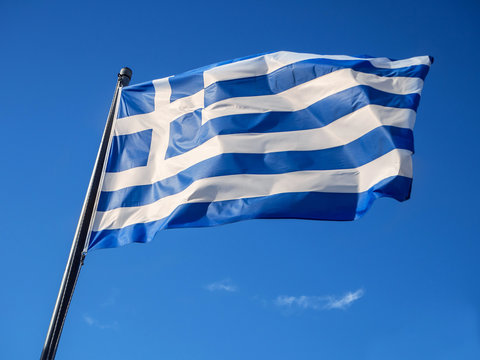 Greek flag waving in blue sky in Greece