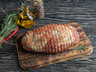 Raw pork roulade. Raw rolled meat enclosed in tied netting. Meat pulp for roasting