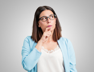 Middle aged woman doubting and confused, thinking of an idea or worried about something