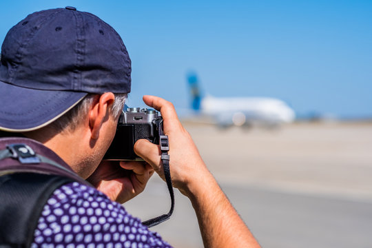 Man taking photos of huge airplane on the airport runway area