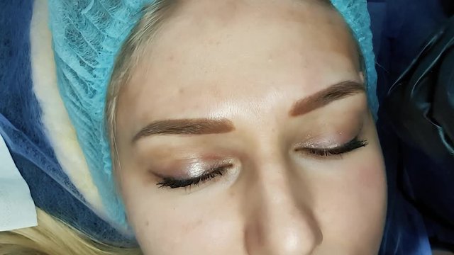Close-up of a woman's face. Permanent eyebrow makeup in a beauty salon