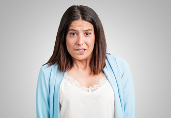 Middle aged woman worried and overwhelmed, forgetful, realize something, expression of shock at...