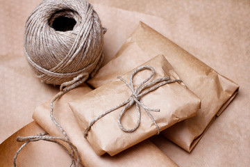 Present wrapped to brown craft paper and tied by cord. Parcel for send. Shop package. 