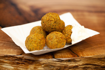 Shawarma sandwich - fresh roll of thin lavash pita bread filled with grilled meat, mushrooms, cheese, cabbage, carrots, sauce, green. Traditional Eastern snack. On a wooden background