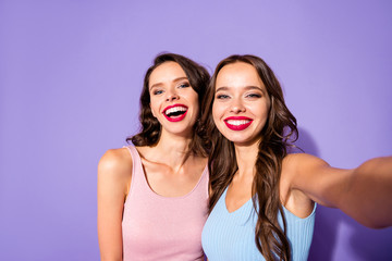 Close up portrait two stunning she her ladies funky prom night make take selfies laugh laughter celebrity makeup cosmetics wear festive dresses isolated purple violet vivid vibrant bright background