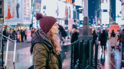 Young woman at New York Times by night