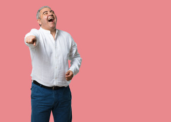 Middle aged man shouting, laughing and making fun of another, concept of mockery and uncontrol
