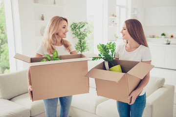 Close up photo two people mum and teen daughter with paper big boxes in arms ready to change decor...