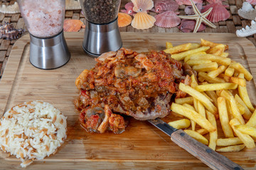 Tender grilled porterhouse or t-bone steak served with crisp golden French fries and fresh green...