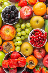 Healthy fruit background filled with strawberries raspberries oranges plums apples kiwis grapes blueberries mango persimmon, top view, selective focus