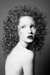 Beautiful nude woman with curly-hair and black lips.