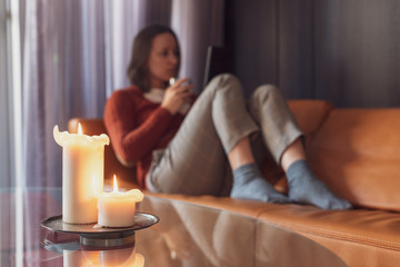 Pretty Girl is reading ebook on the sofa. Reading Concept. Focus on foreground Blurred background. 