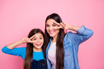 Portrait of two nice cute adorable sweet winsome lovely attractive charming cheerful cheery girls showing v-sign near eyes good mood isolated over pink pastel background