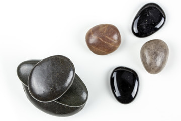 Black pebbles on white background with brown pebble.