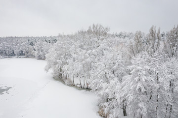 Aerial view of winter beautiful landscape with trees covered with hoarfrost and snow. Winter scenery from above. Landscape photo captured with drone.