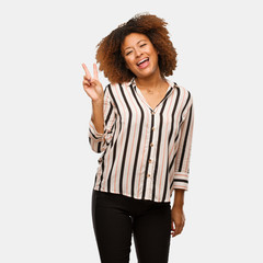 Young black afro woman doing a gesture of victory