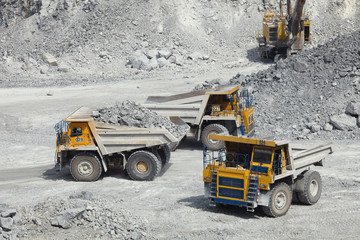 Large mining trucks in a quarry for limestone mining. Mining industry.