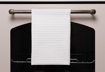 Biały ręcznik kuchenny wisi na piekarnik uchwytem, makiety produktu - 247399836