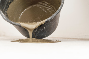 dark bucket. This is the solution for leveling the floor. on the background of the biton floor, and poured out of it