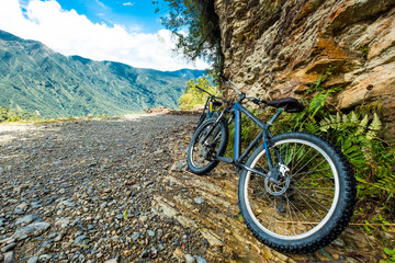 black mountain bikes by the huge brown rock