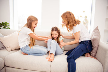 Portrait of nice cute lovely attractive adorable cheerful cheery positive funny ginger hair people mom mommy mum pre-teen girls playing on divan in house indoors