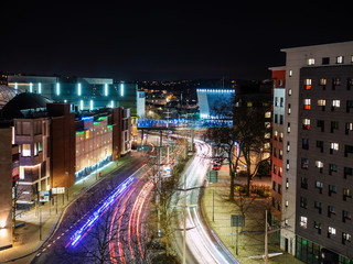 Traffic light trails through futuristic city at night