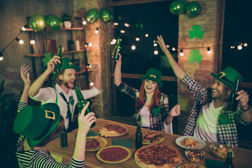 Close up photo people two couples green beverage hold in air hats leaf eat food pizza sausage chips leprechaun costumes checkered plaid shirt rest relax together weekend vacation free time leisure