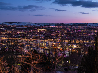 Fototapeta na wymiar Night city scenic with glowing city lights & snowy hilltops, Bristol UK