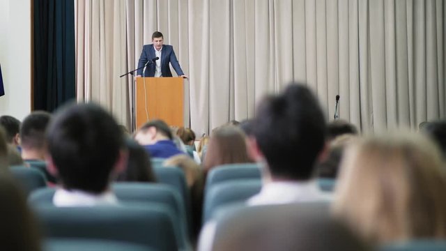 Male announcer conducts a seminar in the hall