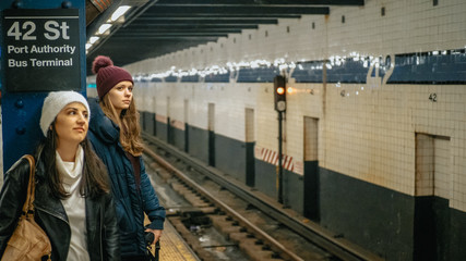 Two girls in New York wait for the subway