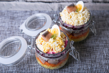 Herring under a Fur Coat. Traditional Russian multilayered salad from herring, beets, potatoes, carrots and eggs. Close-up, selective focus.