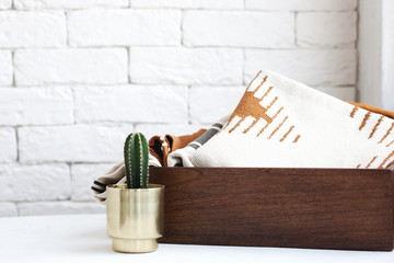 natural fabrics in a wooden basket in front of a white wall in a bright room