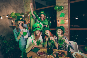 Portrait of nice attractive lovely stylish cheerful cheery glad positive optimistic funny group of people having fun bonding rejoicing festive night life indoors pub cafe bar