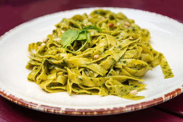 Pasta with pesto sauce and nuts on a the table
