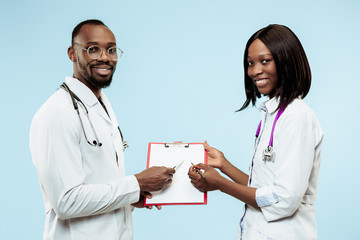 Fototapeta premium The female and male smiling happy afro american doctors on blue background at studio.The clinic, medical, nurse, health, healthcare, hospital, care, job, professional concept