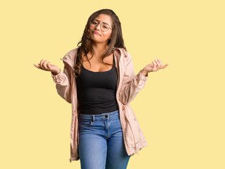 Full body young curvy woman doubting and shrugging shoulders