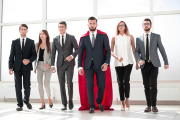 businessman in a red superhero cloak and his business team © ASDF